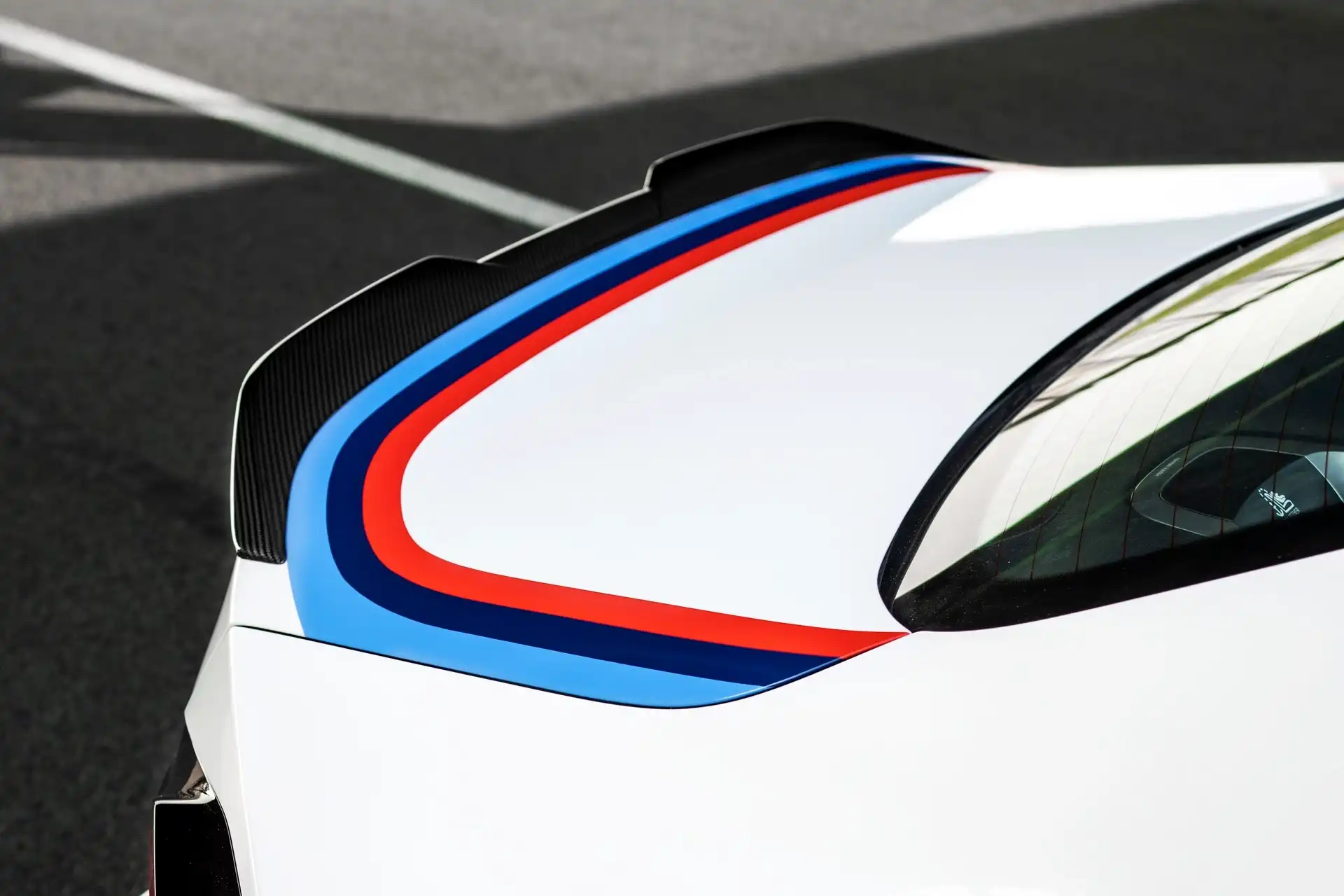 Hand-painted BMW M motorsport graphics across the M2 roof and rear deck
