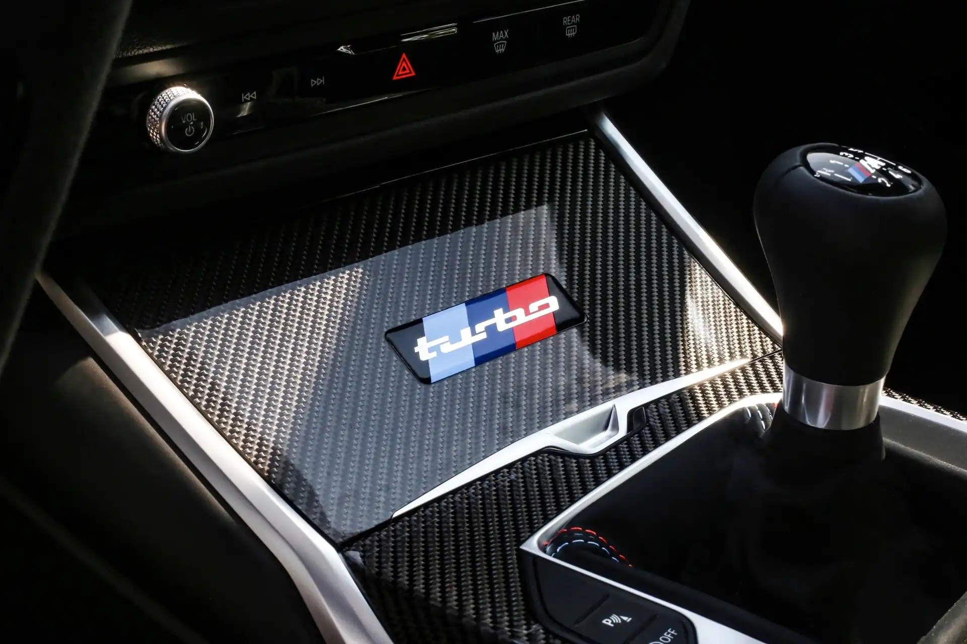 Carbon-fiber center-console trim with turbo emblem