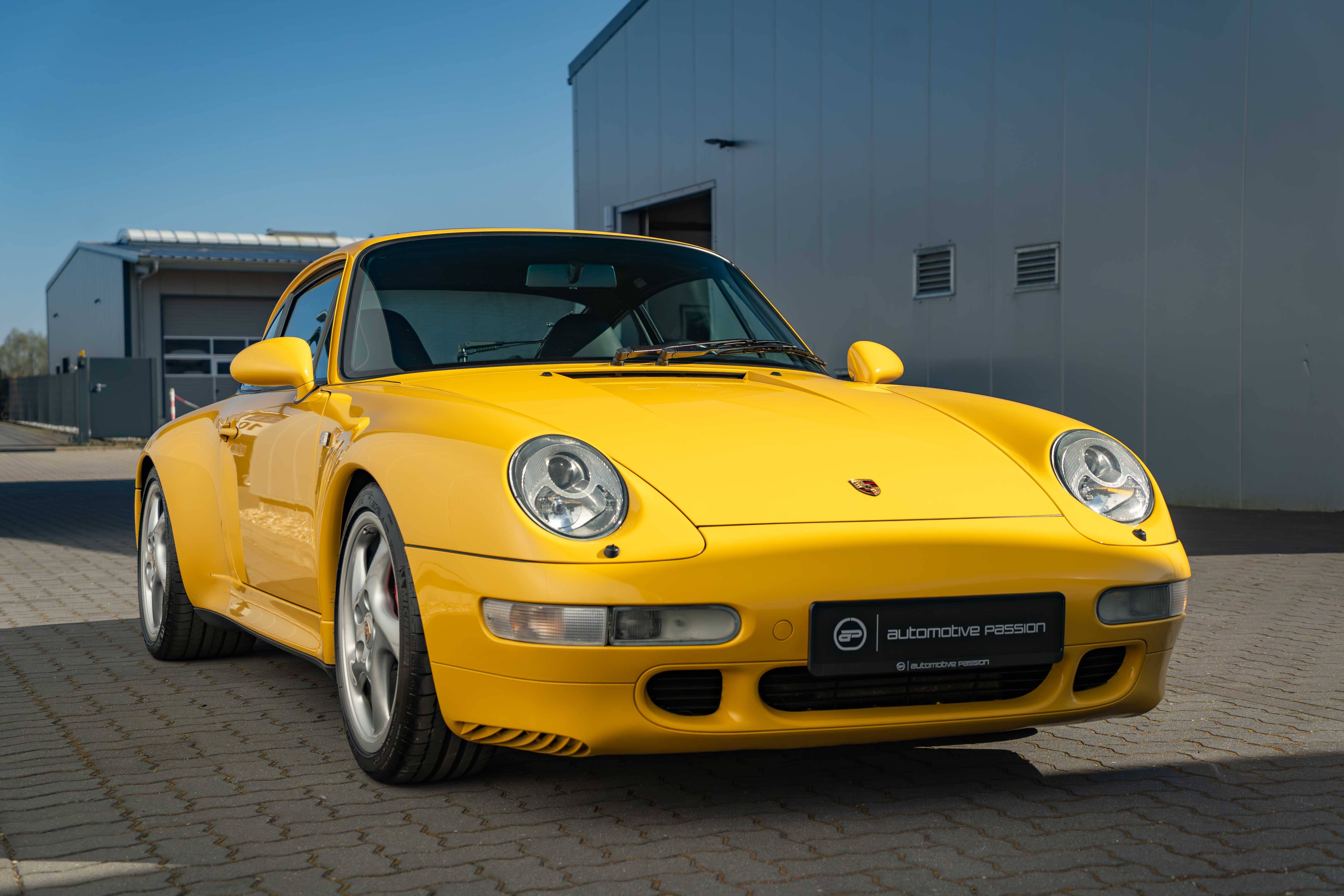 Porsche 993 Carrera 4S in Speedgelb – luftgekühltes Coupé mit breiter Turbo-Optik und klassischen 18-Zoll-Hohlspreichenfelgen, Modelljahr 1997.